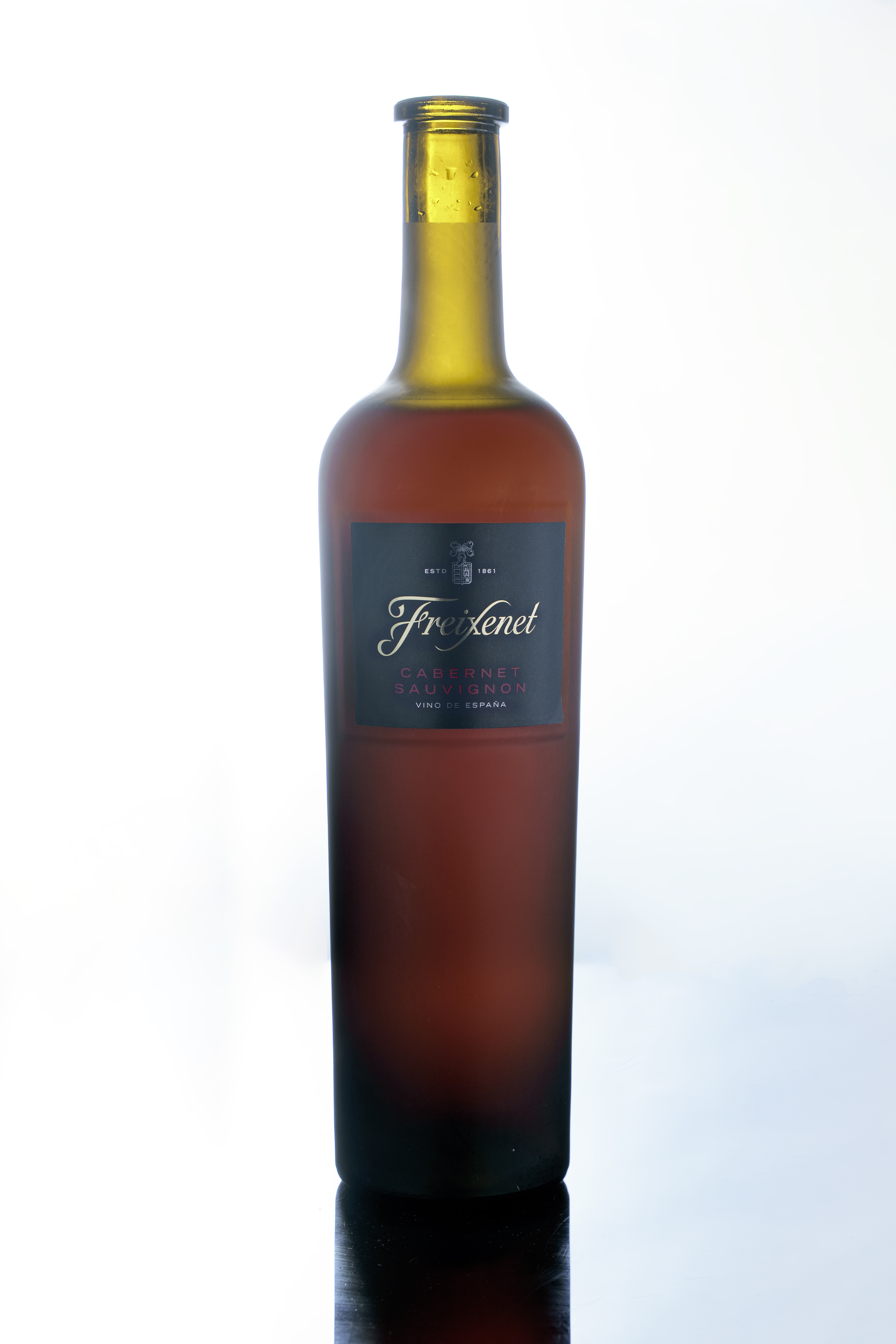 La botella de vino iluminada sobre un fondo claro