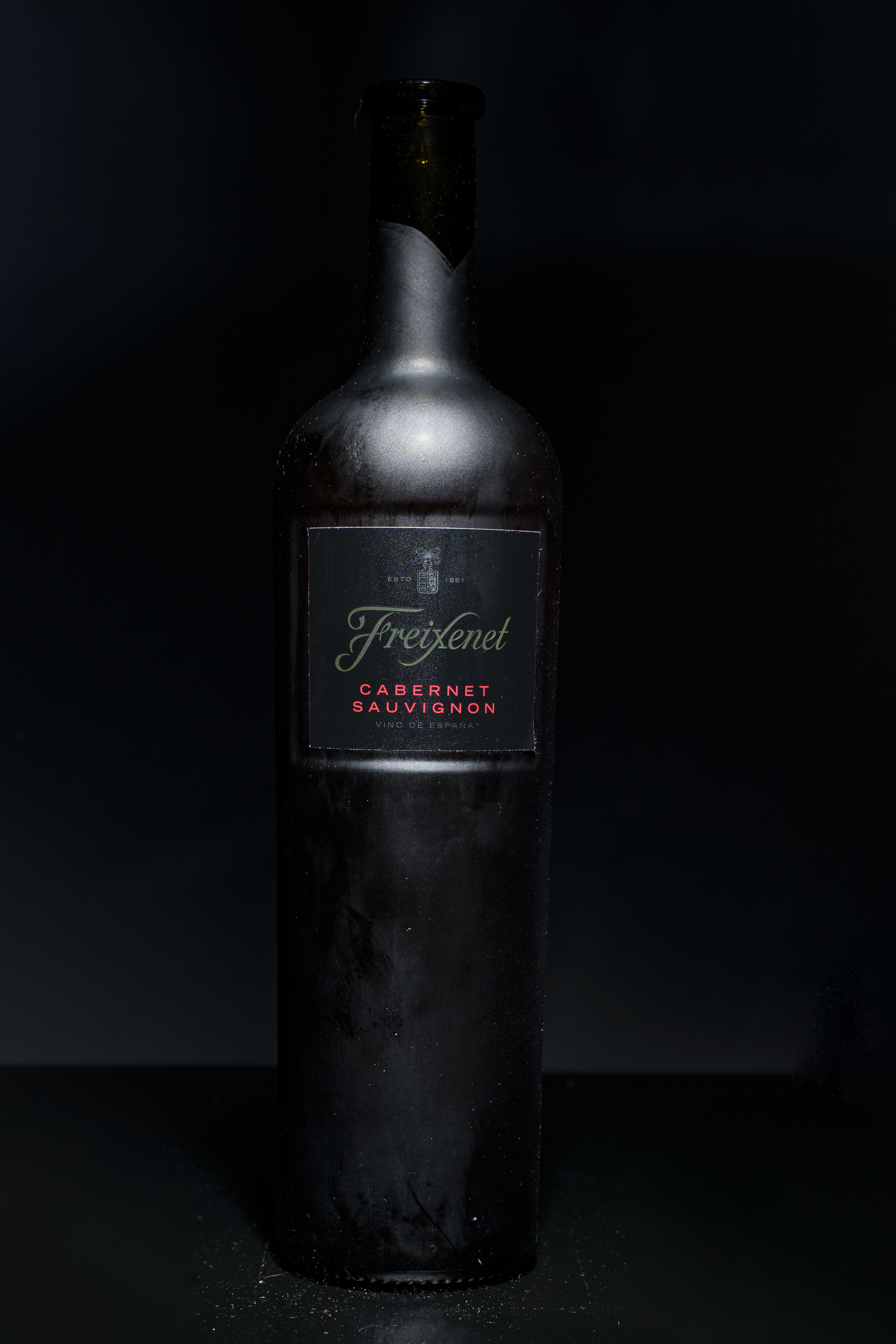 La misma botella con una iluminación tenue y localizada